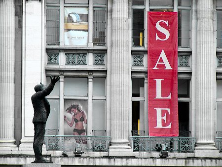 Jim Larkin statue against background of Clery's with Sale sign and poster of woman in underwear